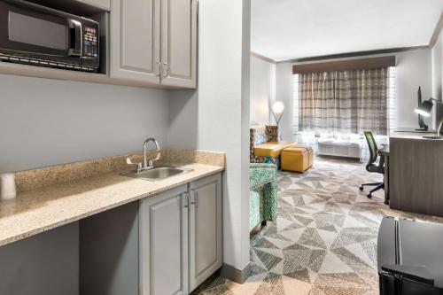 a kitchen with a sink and a living room at Big Country Hotel & Suites, SureStay Collection by BW in Abilene