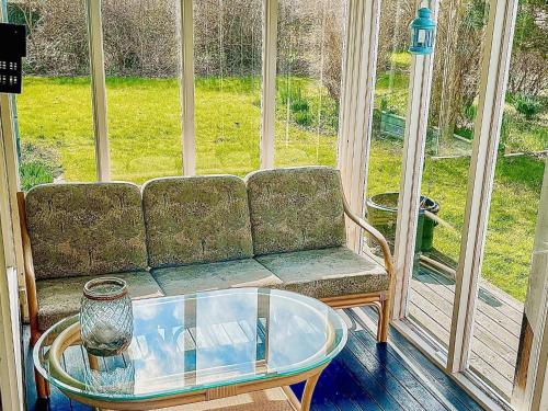 a couch in a room with a glass table and a glass coffee table at 6 person holiday home in Dannemare in Dannemare