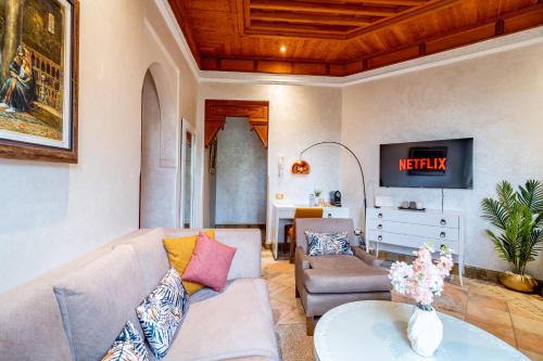 a living room with a couch and a tv at Palm spot in Marrakech