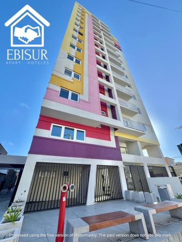 a tall building with colorful paint on it at EBISUR Apart - Hoteles OROMPELLO in Concepción