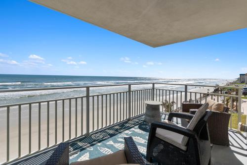a balcony with chairs and a view of the beach at Scenic 2br Beachfront Condo Retreat Nsb Fl in New Smyrna Beach