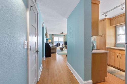 a hallway of a kitchen with a blue wall at Scenic 2br Beachfront Condo Retreat Nsb Fl in New Smyrna Beach