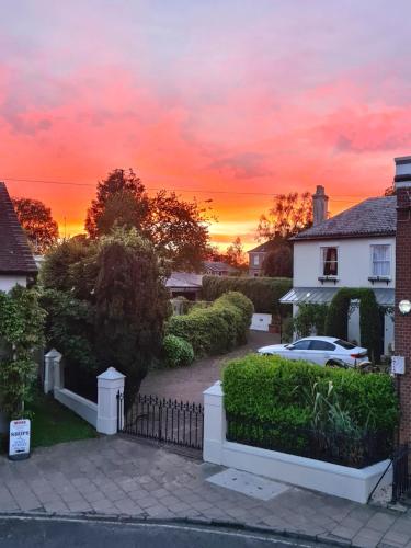 a sunset over a house with a fence at West Street Views #1 - Beautiful town centre apartment in Wimborne Minster