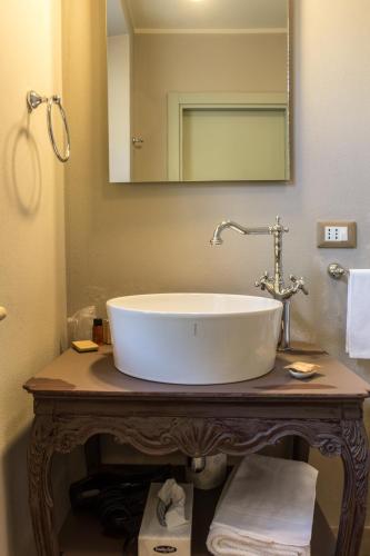 a bathroom with a large white sink on a table at La Maison De Vì in Carpaneto Piacentino
