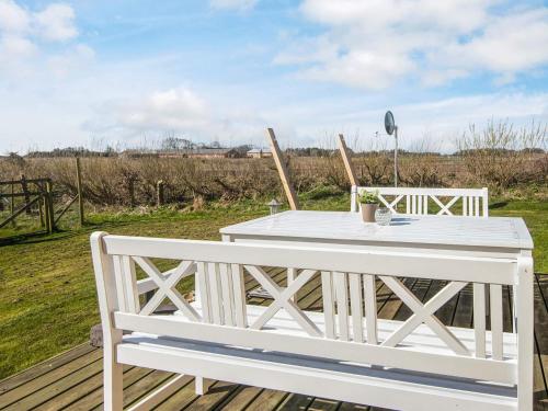 a white table and chairs on a wooden deck at 4 star holiday home in Løkken in Løgsted