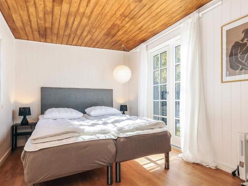 a bedroom with a large bed with a wooden ceiling at 6 person holiday home in Rødby in Rødby