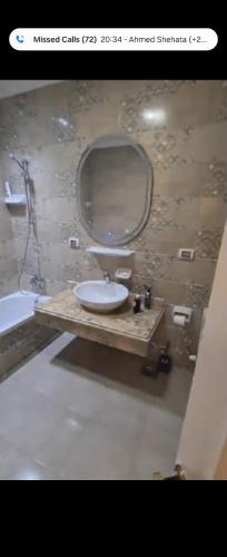 ein Badezimmer mit Waschbecken und Spiegel in der Unterkunft New capital city almaqsed compound in Kafr ash Sharā‘inah