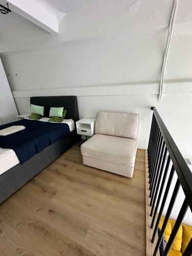 a bedroom with a bed and a couch and a chair at Palanga Studio Apartment with a Pool in Palanga