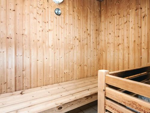 a sauna with a wooden wall with a clock at 10 person holiday home in Bindslev-By Traum in Bindslev