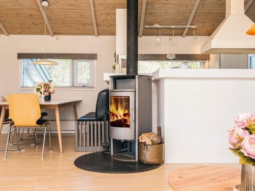 a fireplace in a living room with a table at 10 person holiday home in Bindslev-By Traum in Bindslev