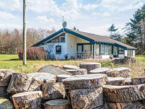 a house with a pile of logs in front of it at 10 person holiday home in Bindslev-By Traum in Bindslev