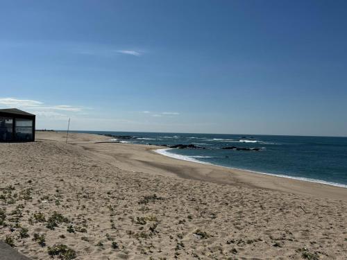a beach with a building and the ocean at Aver Beach Haven in Póvoa de Varzim