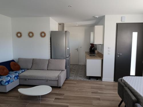 un salon avec un canapé et une table et une cuisine dans l'établissement Maison neuve en centre-ville, à Saint-Hilaire-de-Riez