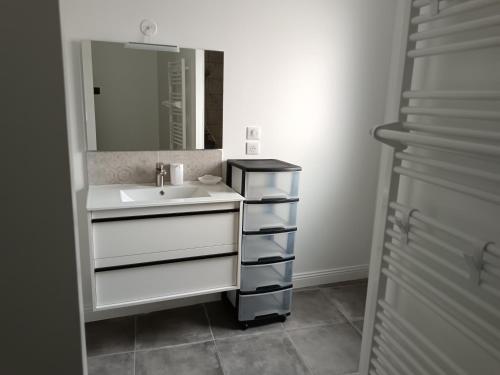 une salle de bain avec un lavabo et un miroir dans l'établissement Maison neuve en centre-ville, à Saint-Hilaire-de-Riez
