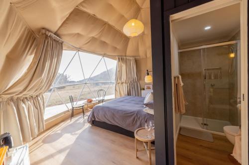 a bedroom with a bed and a large window at Mount Gnomon Farm in Penguin