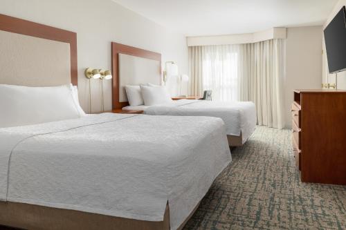 a hotel room with two beds and a television at Homewood Suites by Hilton Ontario Rancho Cucamonga in Rancho Cucamonga