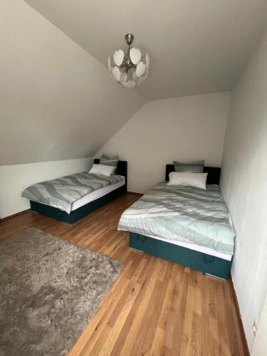 two twin beds in a room with a chandelier at Gemütliche Wohnung in Mesum in Rheine