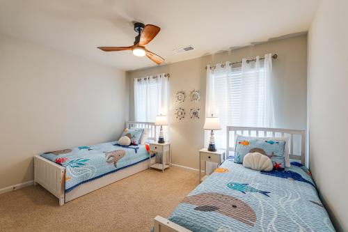 a bedroom with two twin beds and a ceiling fan at 5 Mi to Bethany Beach Townhome with Pool! in Millville