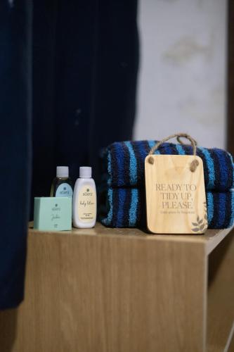 a shelf with two bottles of soap and a bag at Olas Permanentes El Zonte in El Zonte