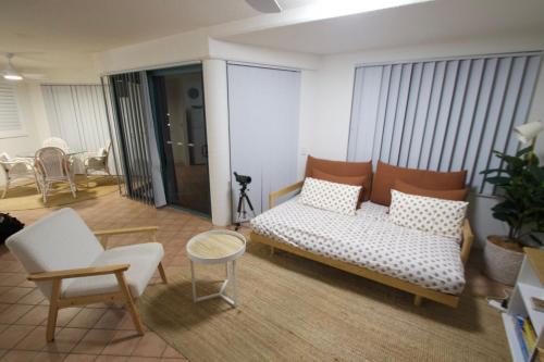 una sala de estar con un sofá, una mesa y sillas en Campbells Cove Unit 12, en Caloundra