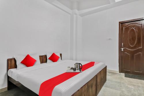 a bedroom with a bed with red pillows at Hotel O Star Stay Guest house opposite Kendriya Bhawan in Lucknow