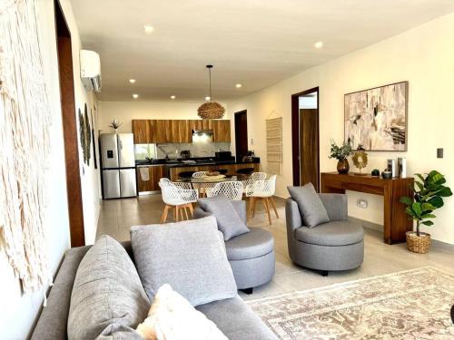 カンクンにあるLovely space in Cancúnのソファと椅子、キッチンのあるリビングルーム