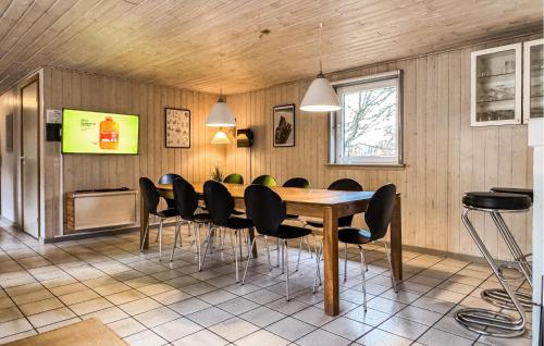 a dining room with a wooden table and black chairs at Amazing Home In Ringkøbing With Kitchen in Søndervig