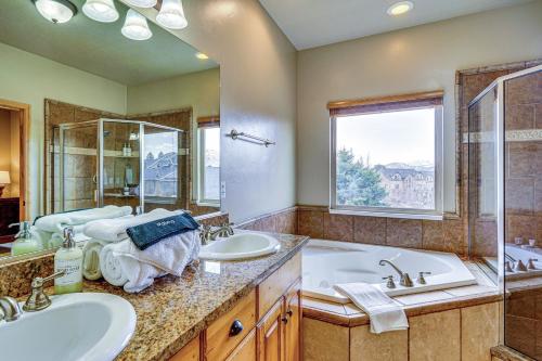 Un baño con dos lavabos y una bañera y una ventana. en Hot Tub and Mtn-View Deck Townhome in Eden, en Eden