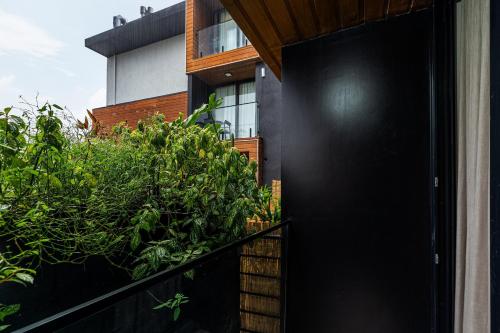 a black door in front of a house with plants at Apartamento You com Piscina e Academia by Achei in Canela