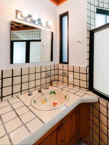 a bathroom with a sink and a mirror at Toro 1, Oro y Azul in Cabo San Lucas