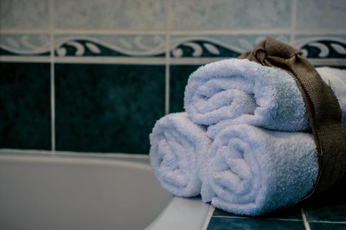 una pila de toallas junto a una bañera en Apartments Maestral, en Trpanj