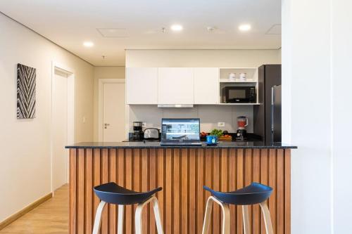 una cucina con bancone e 2 sgabelli blu di Hestia at Asuncion Cozy Bright & Smart 2BDR ad Asunción