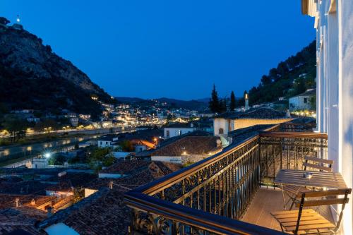 a balcony with a view of a city at night at GrandView Hotel in Berat