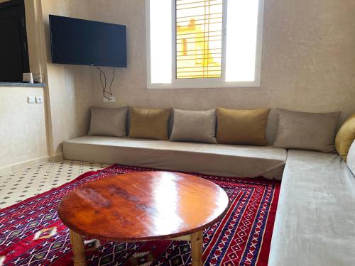 a living room with a couch and a coffee table at Résidence Palmeraie Aglou in Tiznit