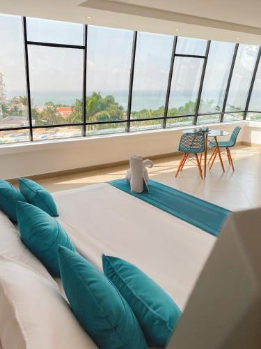 a large bed in a room with large windows at Navio Hotel in Manta