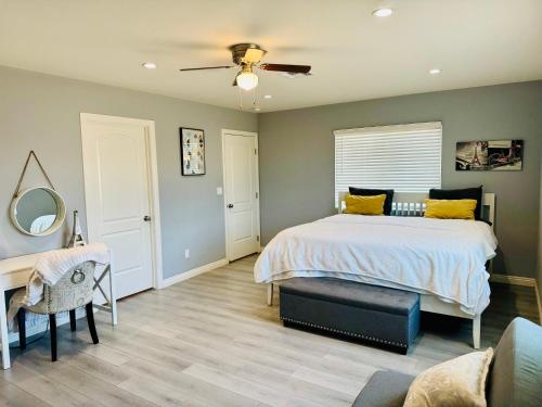 a bedroom with a bed with a ceiling fan and a desk at Beautiful Stay in Moreno Valley - Close to parks in Moreno Valley