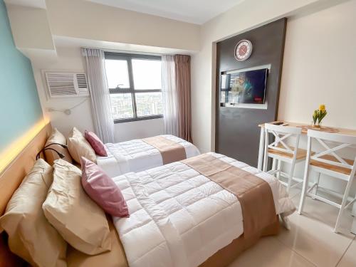 a hotel room with two beds and a window at Cozy Space by Nomad Space PH at Horizons 101 Cebu City with Pool, Netflix, Wifi in Cebu City
