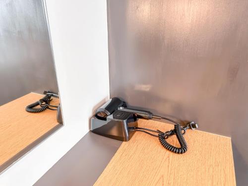 a phone is plugged into a wall with a cord at Cozy Space by Nomad Space PH at Horizons 101 Cebu City with Pool, Netflix, Wifi in Cebu City