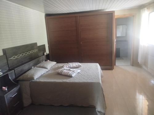 a bedroom with a bed with two pillows on it at Pousada Bella Montanha in Louro Müller