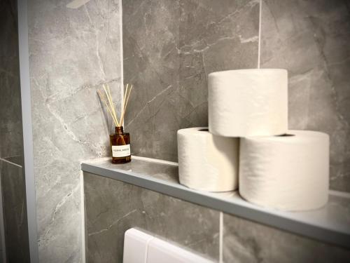 a stack of toilet paper on a shelf in a bathroom at ZOVA - Superior Apartment - near A3 in Willroth