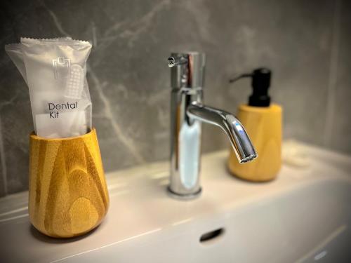 a bathroom sink with a toothbrush holder and a soap dispenser at ZOVA - Superior Apartment - near A3 in Willroth