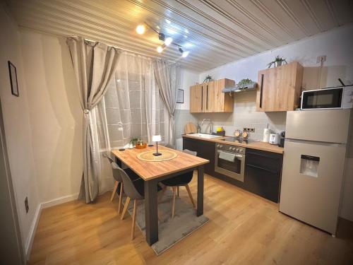 a small kitchen with a table and a refrigerator at ZOVA - Superior Apartment - near A3 in Willroth
