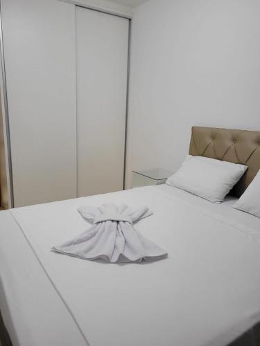 a white bed with a bow on top of it at Egidios AP - Centro de São Pedro da Aldeia in São Pedro da Aldeia