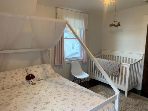 a bedroom with a bunk bed and a baby crib at The Huron stunning water views and family home vibes in Milton in Milton