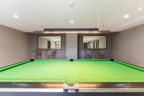 a green pool table in a room with stools at Cozy Space by Nomad Space PH at Horizons 101 Cebu City with Pool, Netflix, Wifi in Cebu City