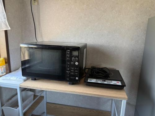 a microwave sitting on top of a table at 民泊中村邸 in Nagato