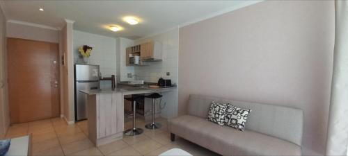 a living room with a couch and a kitchen at Departamento Central 1D - Wifi - Parking in Antofagasta