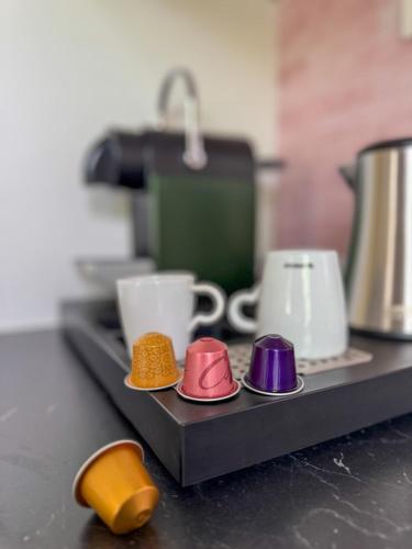 a tray with four different colored plates and cups at Genk Central Apartment in Genk