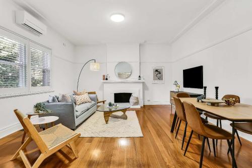 a living room with a couch and a table at Large 3 Bed Art Deco Apartment in Camberwell in Melbourne