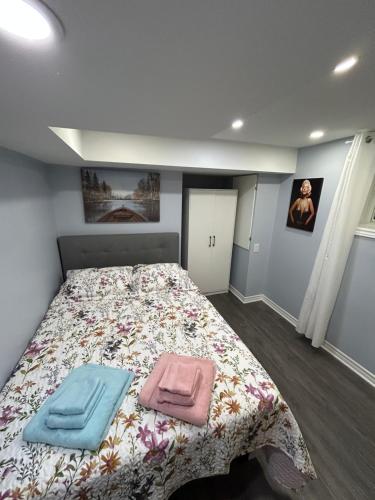 a bedroom with a bed with two towels on it at Beautiful and cozy unit in Mississauga